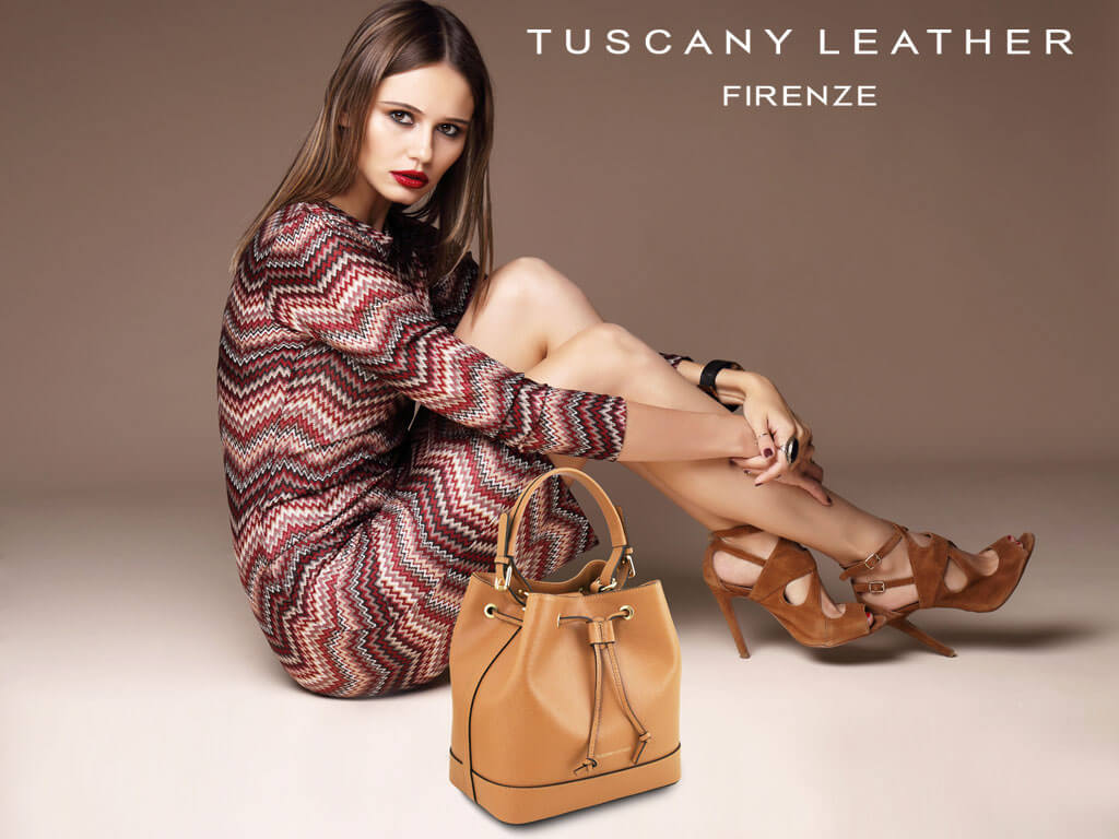 Woman combining a patterned outfit with a leather handbag